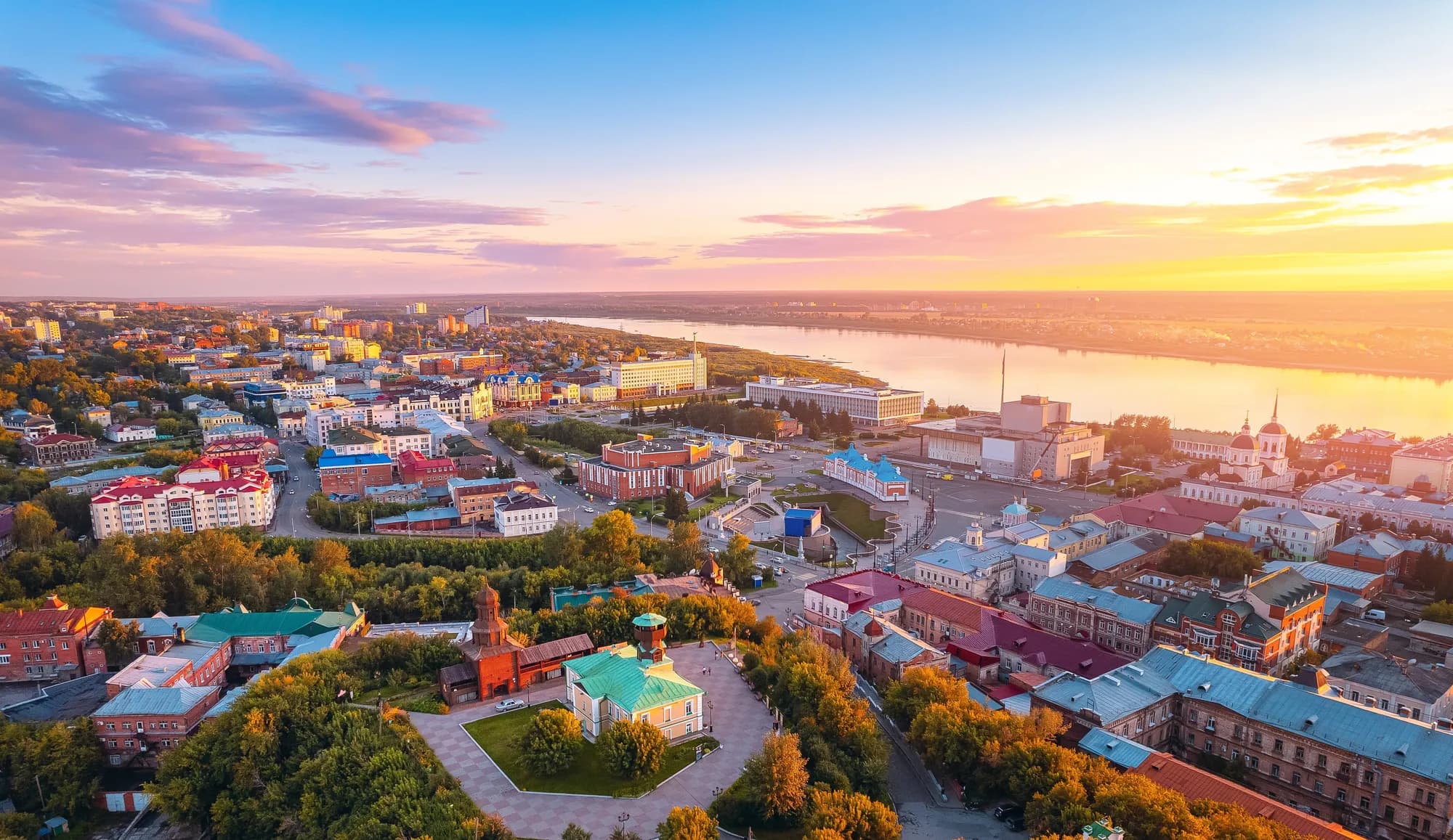 Панорама города Томска на закате, вид на деревянную архитектуру и реку Томь